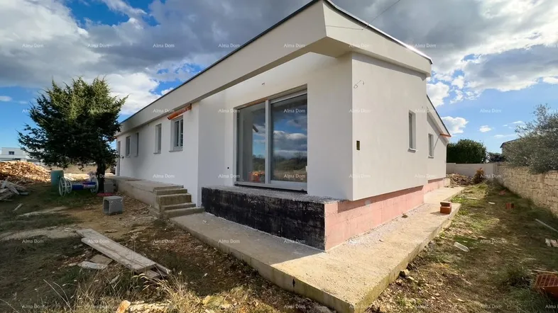 Moderner Neubau im Rohbauzustand mit weißer Fassade, großen Fenstern und einfacher Außengestaltung.