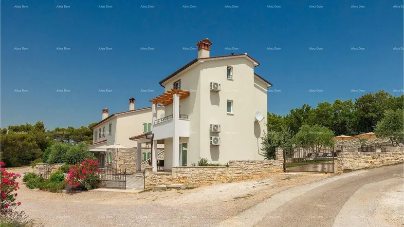 Ansicht des Hauses von außen mit heller Fassade, umgeben von mediterraner Vegetation und einem Steinweg.