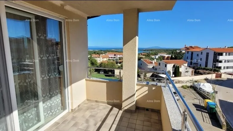 Großer Balkon mit Fliesenboden und weitem Blick auf die Stadt und das Meer.
