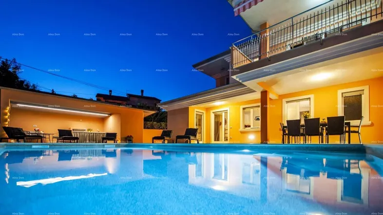 Beleuchteter Außenbereich mit großem Pool und Terrasse bei Nacht, ideal für entspannte Abende.