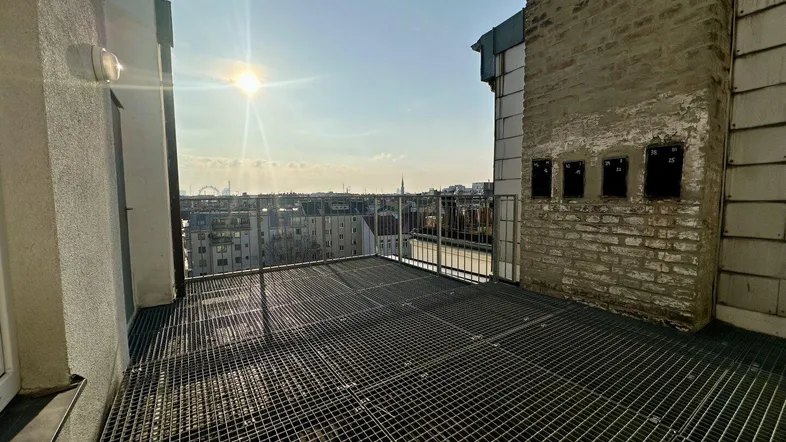Große Dachterrasse mit Metallgitterboden bietet einen weiten Blick über die Stadt an einem sonnigen Tag.