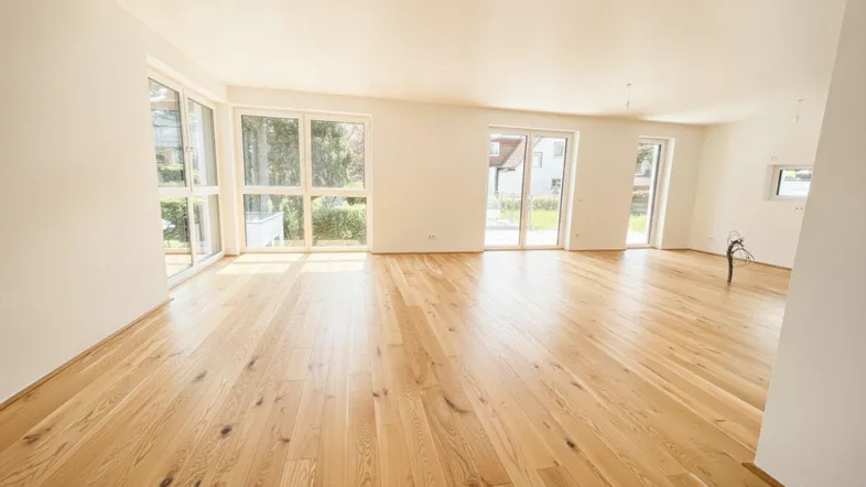 Helles, geräumiges Wohnzimmer mit Eichenparkett und großen Fenstern, die viel Tageslicht hereinlassen.