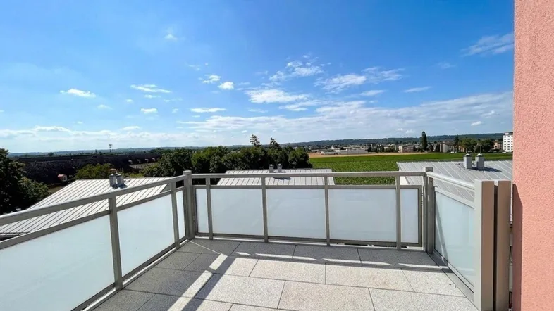 Geräumige Sonnenterrasse mit Fliesenboden und weitem Blick über die umliegende Landschaft.