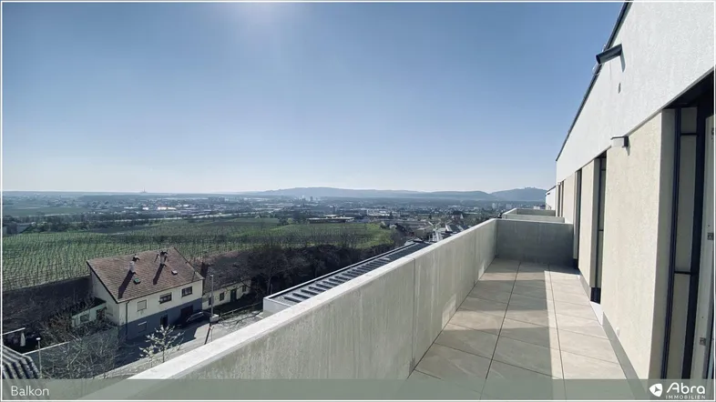 Großer Balkon mit Fliesenboden und weitem Blick über Weinberge und die umliegende Landschaft.