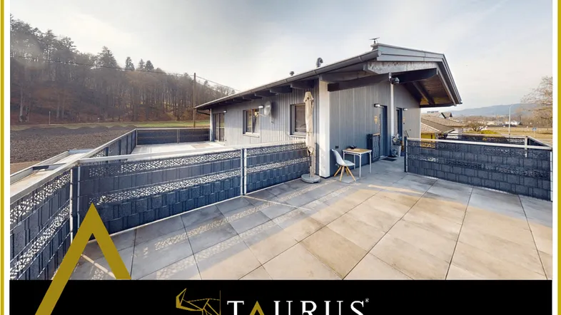 Große, sonnige Terrasse mit modernen Fliesen und Blick auf die umliegende Natur.