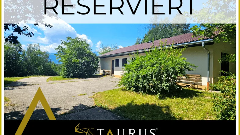 Außenansicht eines gepflegten Gebäudes mit Satteldach, umgeben von viel Grün und einem weiten Blick.