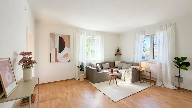 Helles Wohnzimmer mit Parkettboden, gemütlichem Ecksofa und moderner Dekoration.