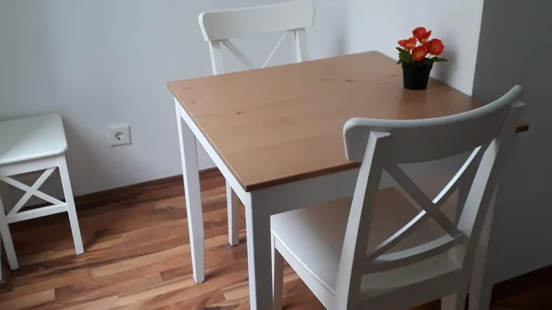 Heller Essbereich mit Holztisch, weißen Stühlen und Parkettboden für gemütliche Mahlzeiten.