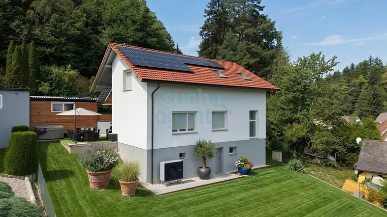 Modernes Einfamilienhaus mit Photovoltaikanlage, Wärmepumpe und gepflegtem Garten in grüner Hanglage.