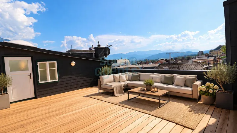 Geräumige Dachterrasse mit Holzboden, bequemen Loungemöbeln und weitem Bergblick über die Stadt.