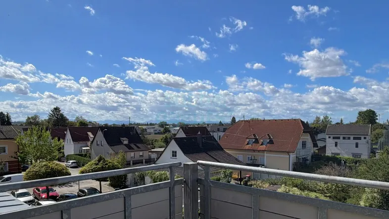 Panoramablick von einem Balkon über eine Wohnsiedlung mit Häusern und weitem Himmel.