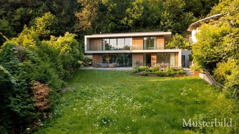 Zeitgenössisches Wohnhaus mit weitläufigem Garten und großen Fensterfronten in grüner Umgebung.