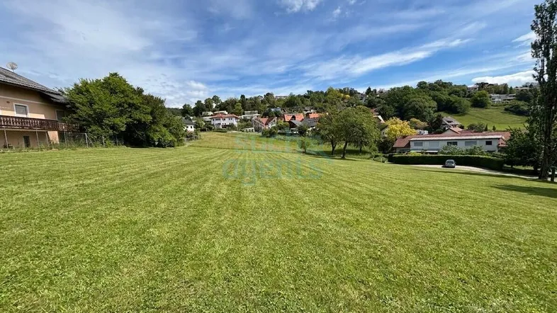 Weitläufige Grünfläche mit Blick auf die umliegende Wohnbebauung und eine sanfte Hügellandschaft.