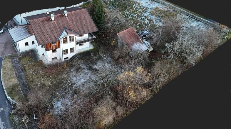 Luftaufnahme eines Wohnhauses mit großem Grundstück und Nebengebäude in ländlicher Umgebung.