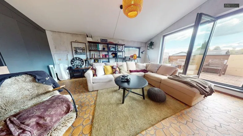 Helles Wohnzimmer mit gemütlichem Sofa, Holzboden und Zugang zu einer Terrasse.
