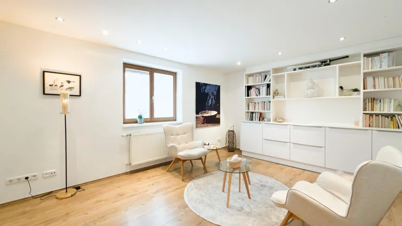 Helles Wohnzimmer mit Parkettboden, Einbauregalen und gemütlicher Sitzecke für entspannte Stunden.