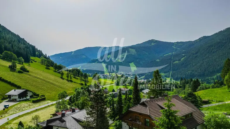 Panoramablick auf die umliegende Berglandschaft mit mehreren Häusern im Tal.