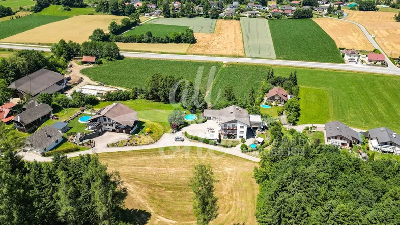 Luftaufnahme einer ländlichen Wohngegend mit Häusern, Feldern und viel Grün.