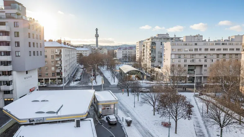 Winterliche Stadtansicht von oben mit verschneiten Gebäuden, Straßen und einem Gasthaus.