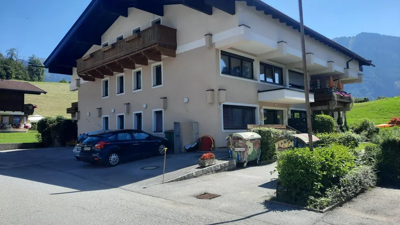 Traditionelles Haus mit Holzbalkonen und Bergblick in ländlicher Umgebung.