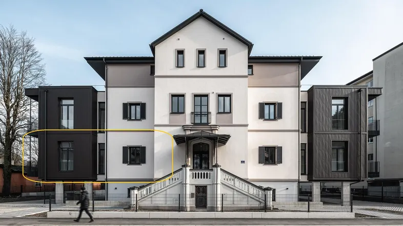 Die Fassade des Gebäudes kombiniert traditionelle Elemente mit modernen Anbauten und dunklen Akzenten.
