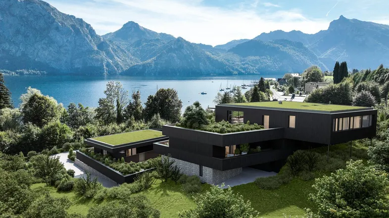 Moderne Architektur mit Flachdach und begrünten Terrassen, eingebettet in eine beeindruckende Berg- und Seenlandschaft.