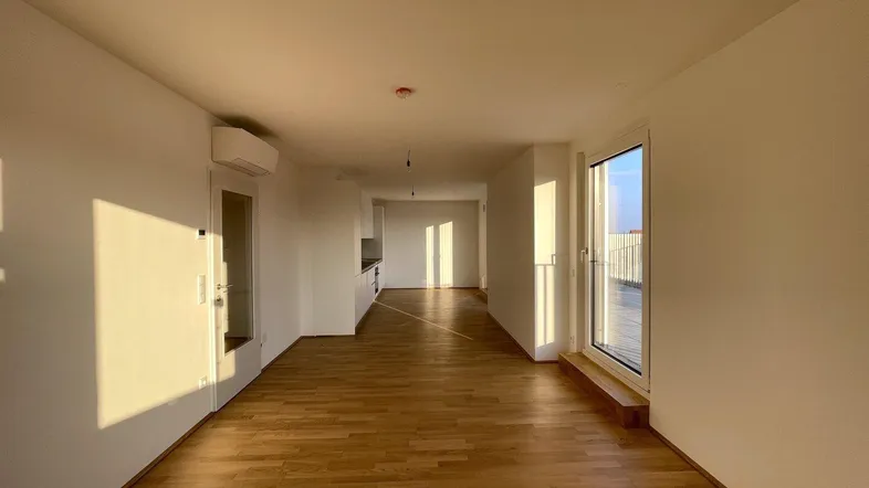 Helles, offenes Wohnzimmer mit Holzboden, Klimaanlage und Zugang zu einer großen Terrasse.
