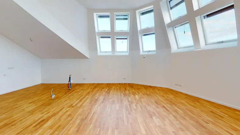 Heller Dachgeschossraum mit Holzboden und vielen Dachfenstern, ideal als Wohnbereich nutzbar.