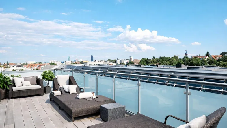 Geräumige Dachterrasse mit bequemen Lounge-Möbeln und weitem Blick über die Stadt.