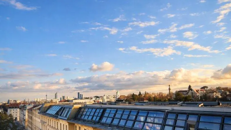 Architektonische Ansicht einer modernen Gebäudefassade mit vielen Fenstern und Dachgauben.