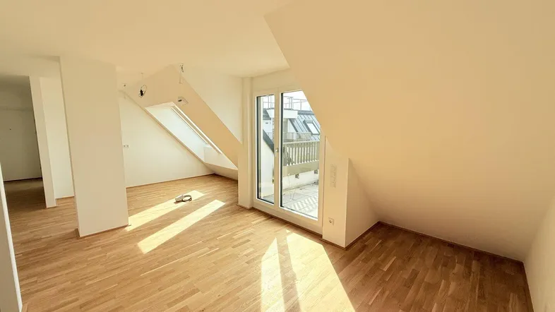 Helles Dachgeschosszimmer mit Parkettboden, Dachfenstern und Zugang zur Terrasse, lichtdurchflutet.
