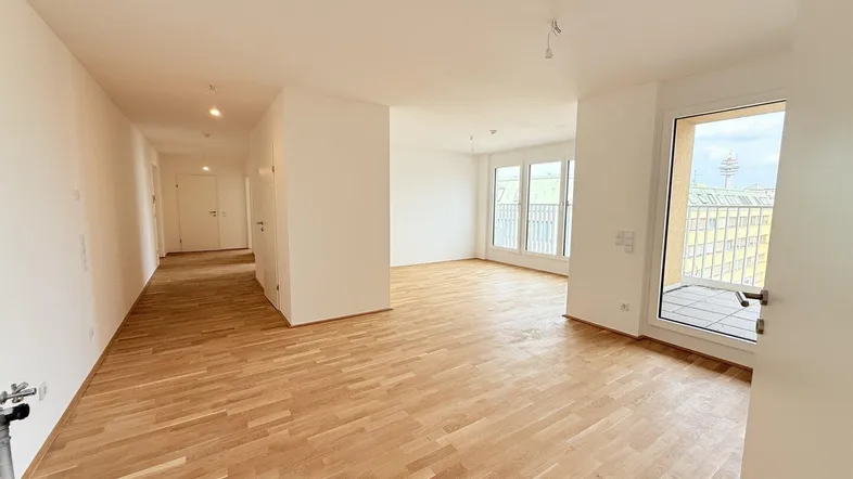 Helles, leeres Zimmer mit Parkettboden und Zugang zu einem Balkon, bereit zur individuellen Gestaltung.