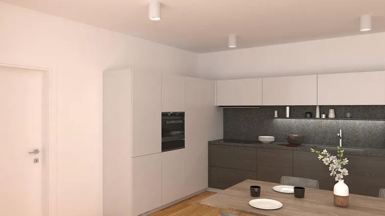 Moderne Küche mit integrierten Geräten, dunkler Arbeitsplatte und hellem Holzboden, kombiniert mit einem Essbereich.