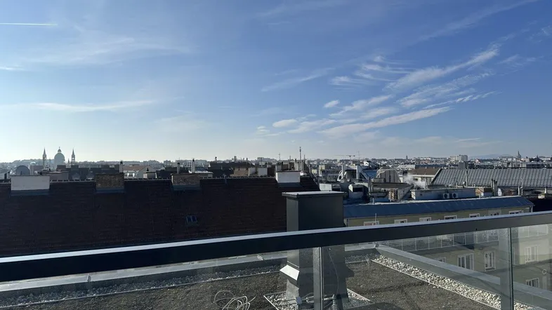 Geräumige Dachterrasse mit weitem Blick über die Stadt und die umliegenden Dächer.