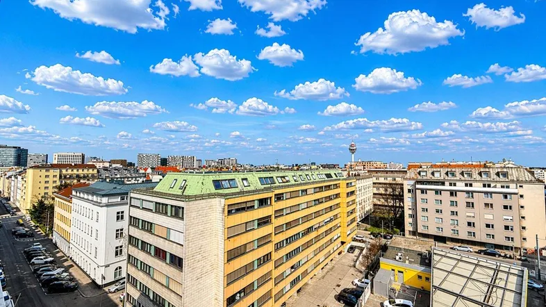 Panoramablick über die Stadt mit zahlreichen Gebäuden und einem Fernsehturm am Horizont.