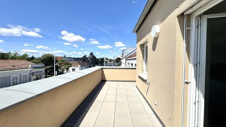 Große, sonnige Terrasse mit Fliesenboden und weitem Blick über die Umgebung.