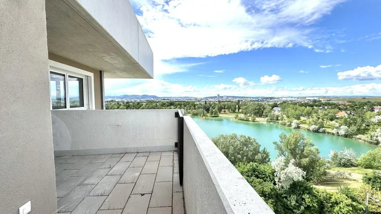 Geräumiger Balkon mit Fliesenboden und weitem Blick auf den See und die Stadt.