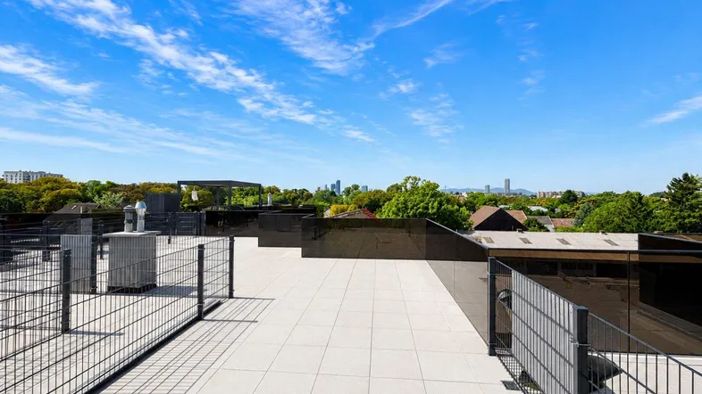 Geräumige Dachterrasse mit Fliesenboden und weitem Blick über die Stadt und die Umgebung.