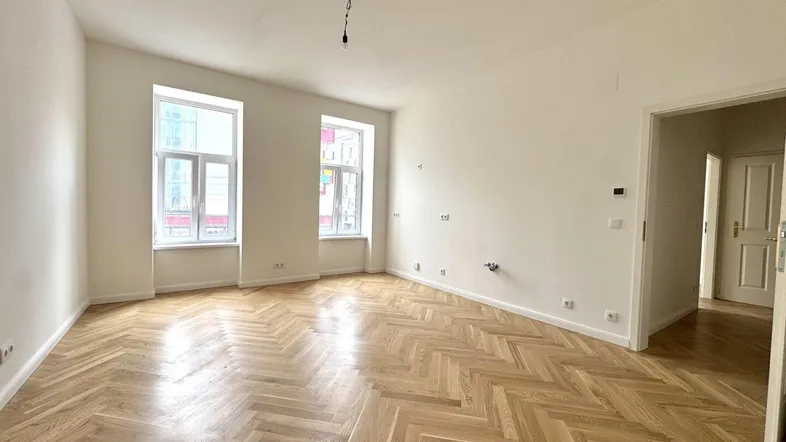 Helles, frisch renoviertes Zimmer mit Fischgrätparkett und hohen Decken, bereit zur individuellen Gestaltung.
