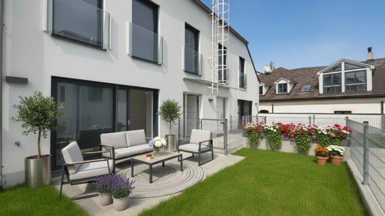 Möblierte Terrasse mit Rasenfläche und Blick auf die moderne Gebäudefassade.