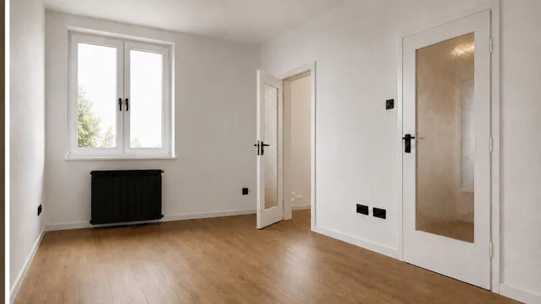 Heller, leerer Raum mit Laminatboden, großen Fenstern und weißen Türen.
