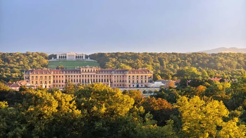 Malerischer Blick auf das Schloss Schönbrunn und die Gloriette, umgeben von üppiger Natur.