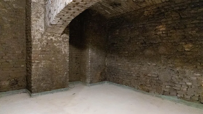 Historischer Kellerraum mit unverputzten Ziegelwänden und einem beeindruckenden Gewölbe, der viel Potenzial bietet.