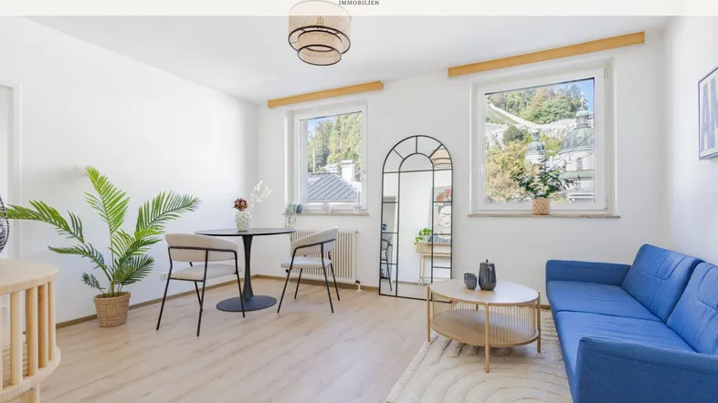 Helles Wohn- und Esszimmer mit modernem Interieur, Holzboden und Blick ins Grüne.