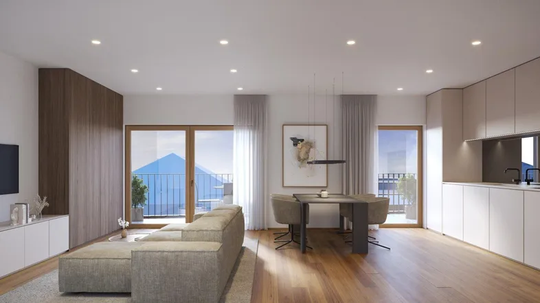 Heller, offener Wohn-Essbereich mit integrierter Küche, Holzboden und Zugang zum Balkon.