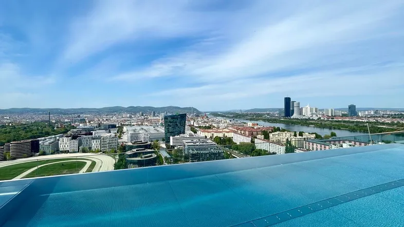 Infinity-Pool auf dem Dach mit atemberaubendem Blick über die Stadt und den Fluss.