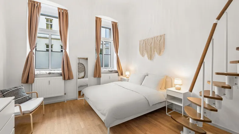 Helles Schlafzimmer mit Holzboden, einer Wendeltreppe und moderner Einrichtung im Loft-Stil.