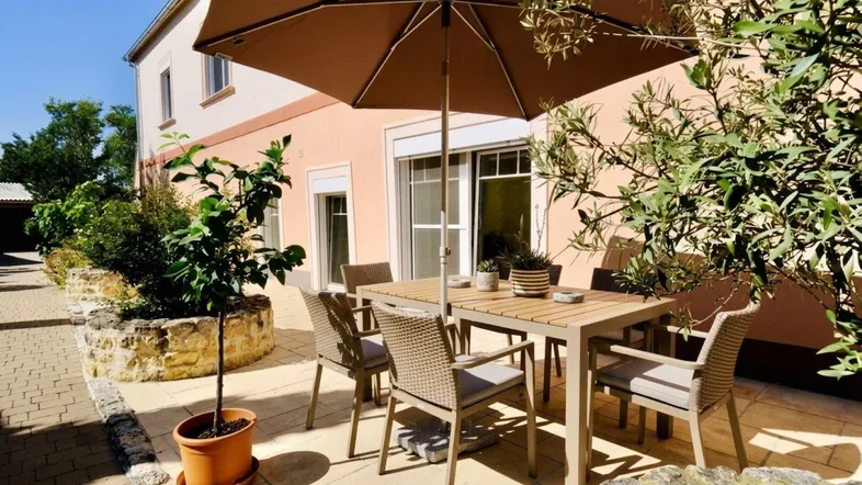 Gemütliche Terrasse mit Gartenmöbeln und Sonnenschirm, ideal für entspannte Stunden im Freien.
