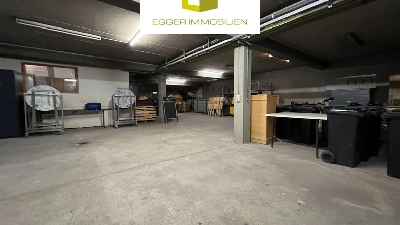 Großer, funktionaler Lagerraum mit Betonboden und sichtbaren Deckeninstallationen, ideal für gewerbliche Nutzung.