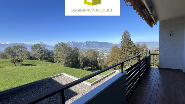 Geräumiger Balkon mit Fliesenboden und weitem Blick auf die Berge und grüne Landschaft.